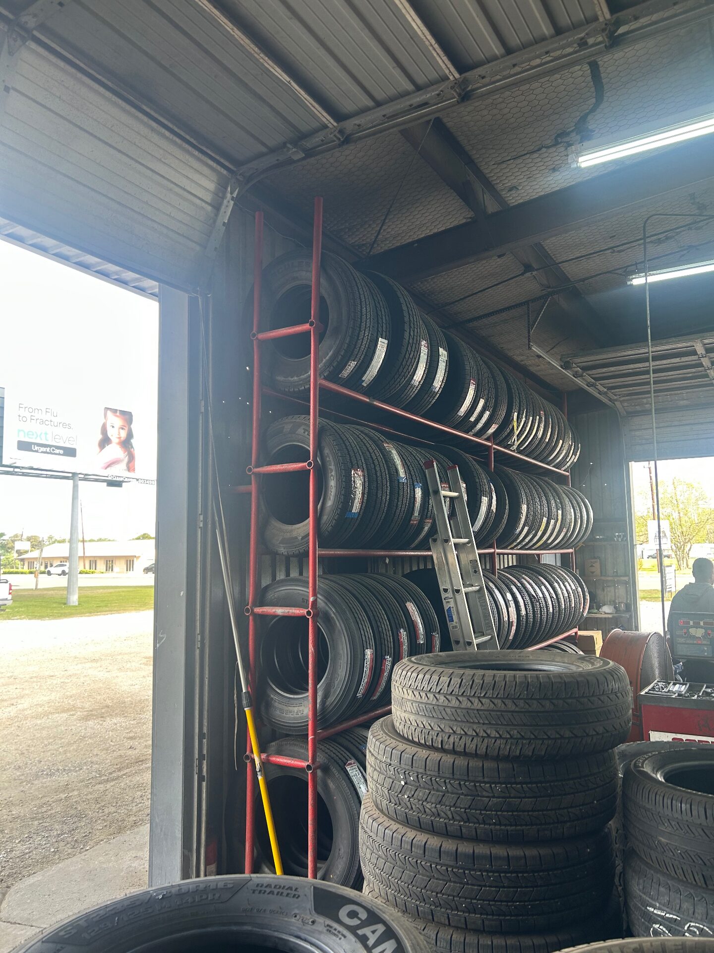 Tire racks stacked with new tires near the bay door