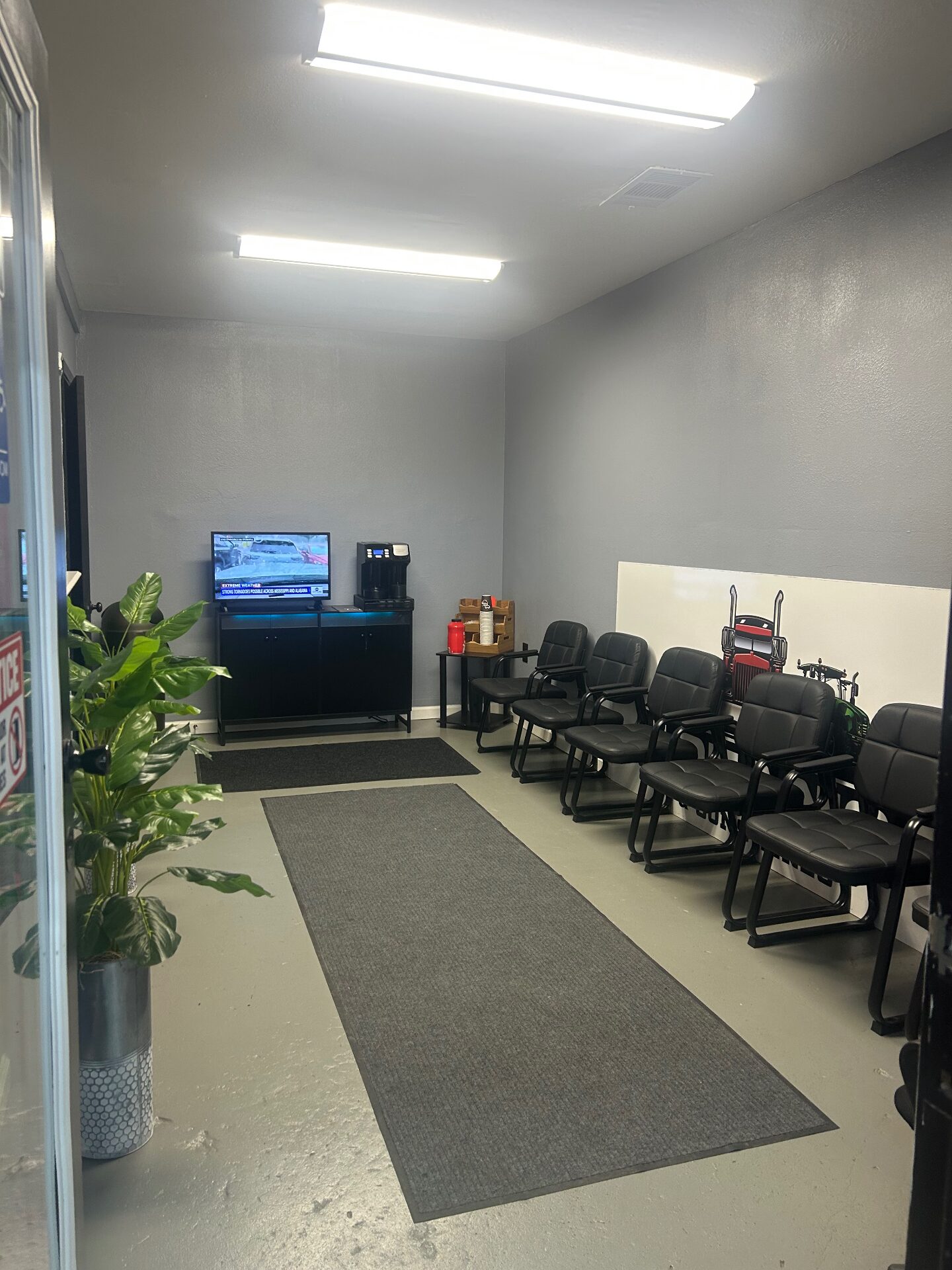 Customer waiting area with comfortable seating, TV and coffee station
