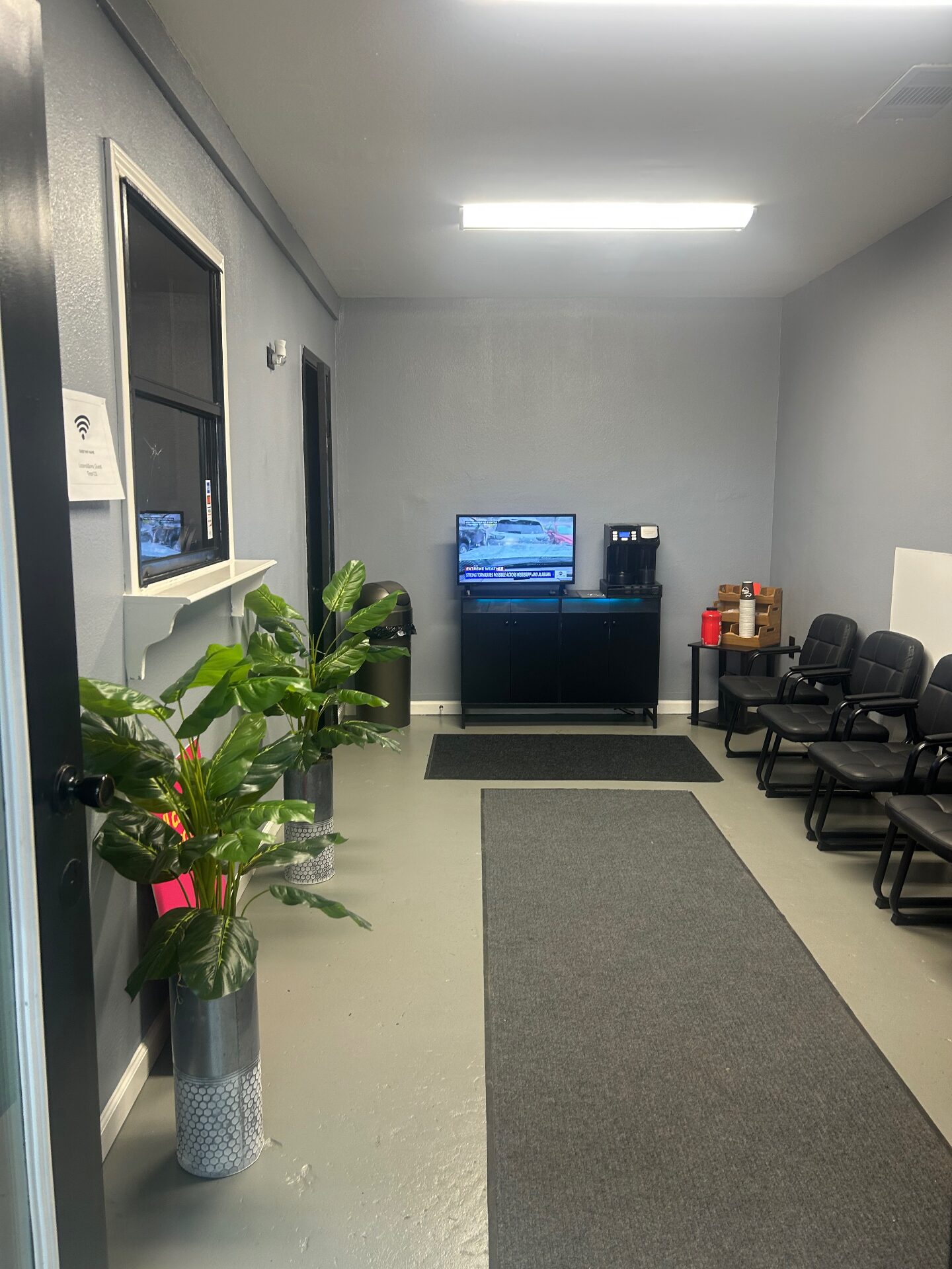 Clean waiting room with chairs, plants and refreshments for customers